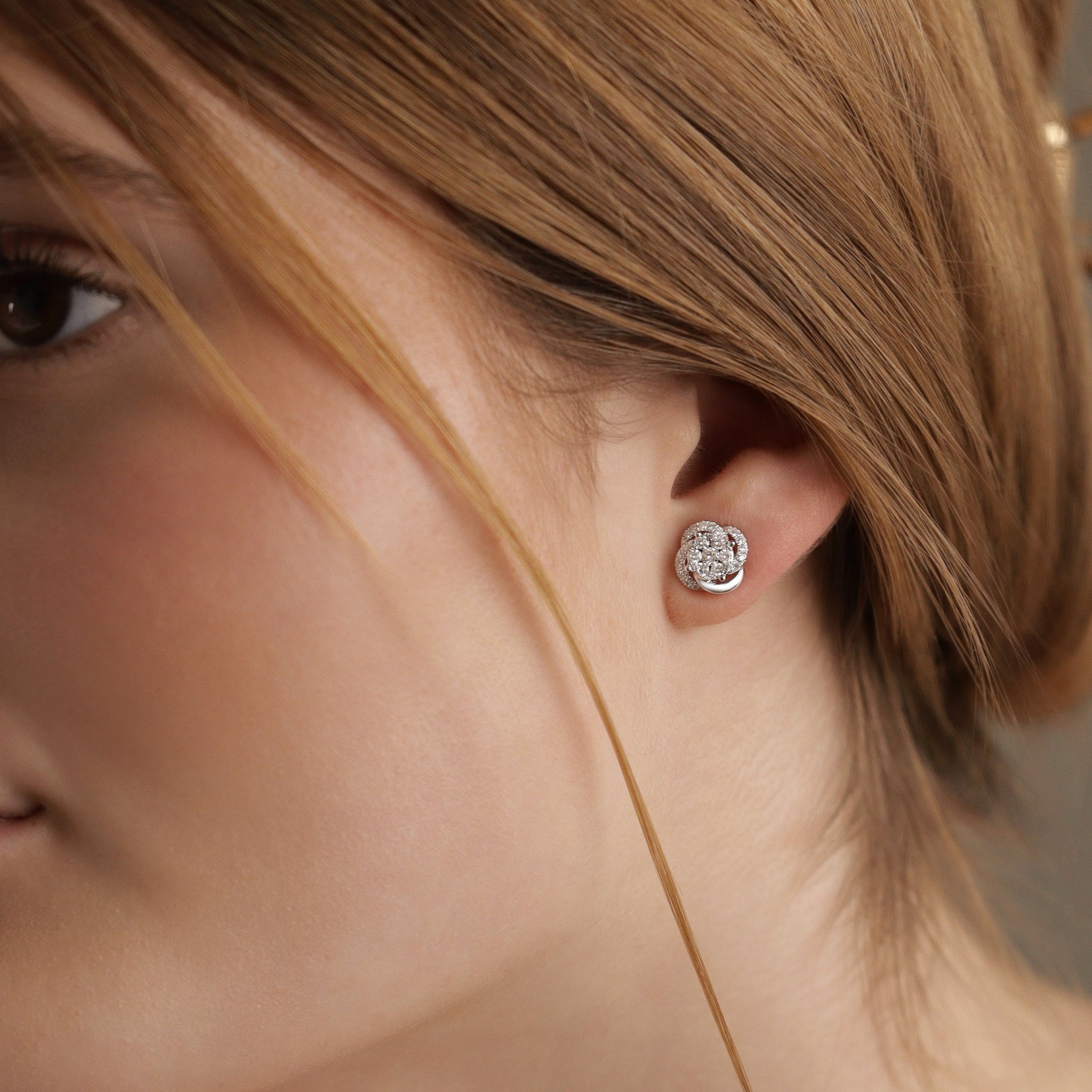 Celine Ohrstecker aus 18 Karat Gold mit pavegefassten Diamanten -getragen am Ohr, eleganter Feinschmuck für Damen.