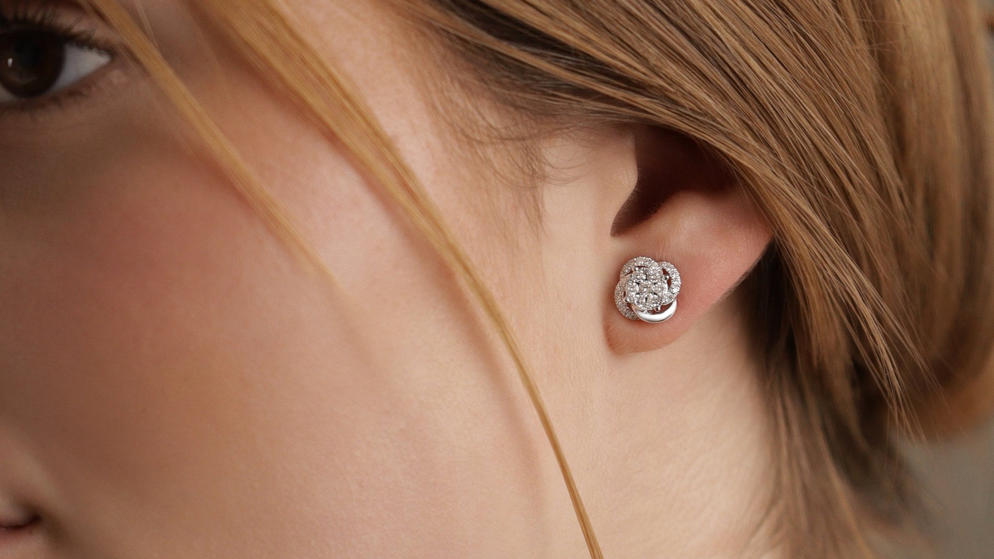 Celine Ohrstecker aus 18 Karat Gold mit pavegefassten Diamanten -getragen am Ohr, eleganter Feinschmuck für Damen.