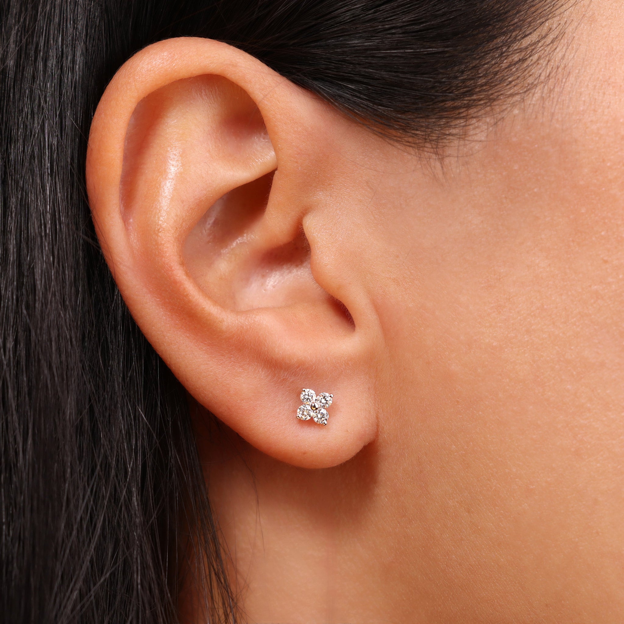 Julie Ohrstecker in 18k Weißgold mit vier funkelnden Brillanten - elegante Blütenform, getragen am Ohr