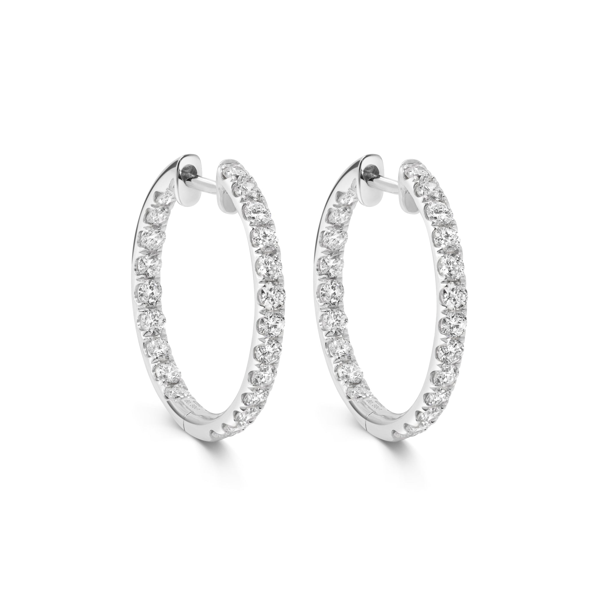 Creolen aus 18 Karat Weißgold, innen und außen mit runden Brillanten besetzt, freigestellt vor weißem Hintergrund.