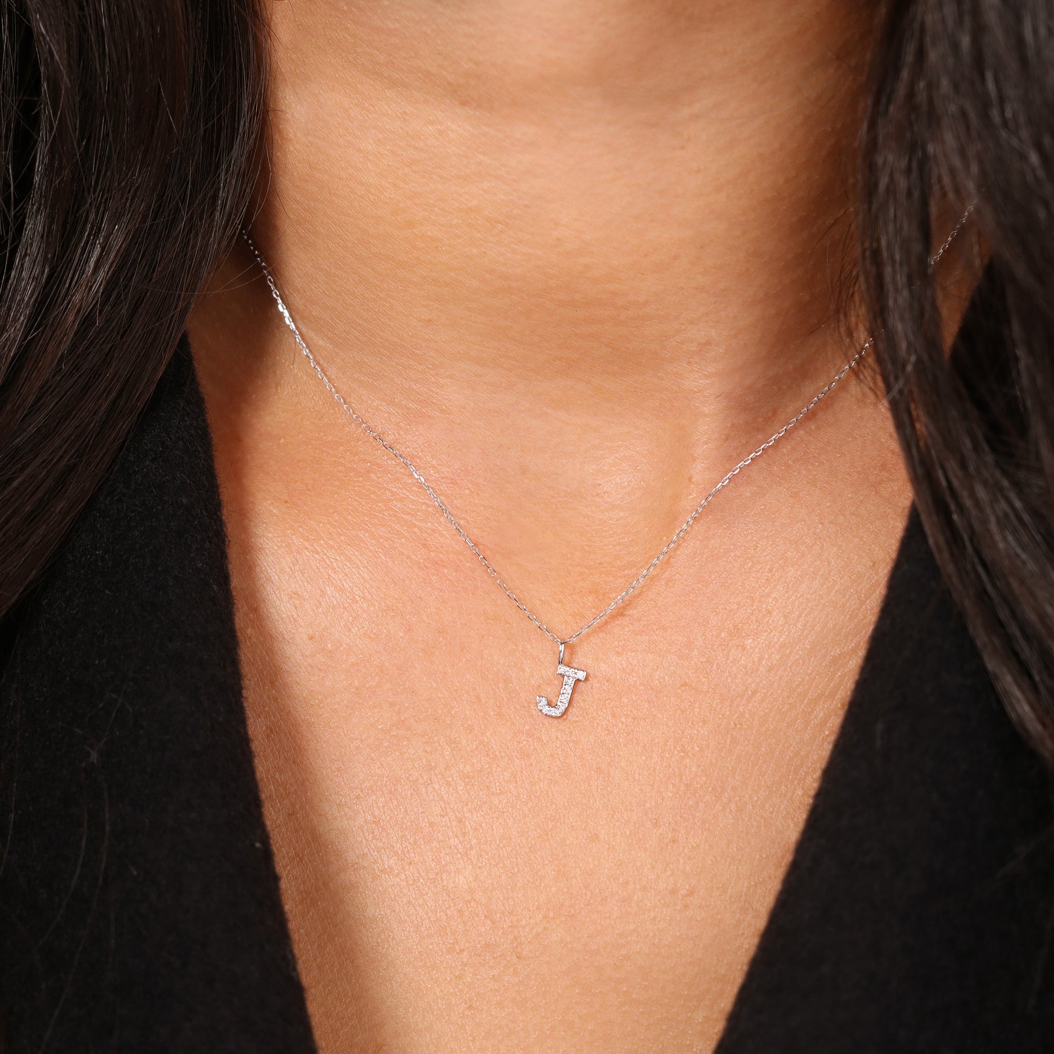 Feine J-Buchstaben-Halskette aus 18k Weißgold mit Diamanten - eleganter Initialschmuck für Damen, getragen am Hals.