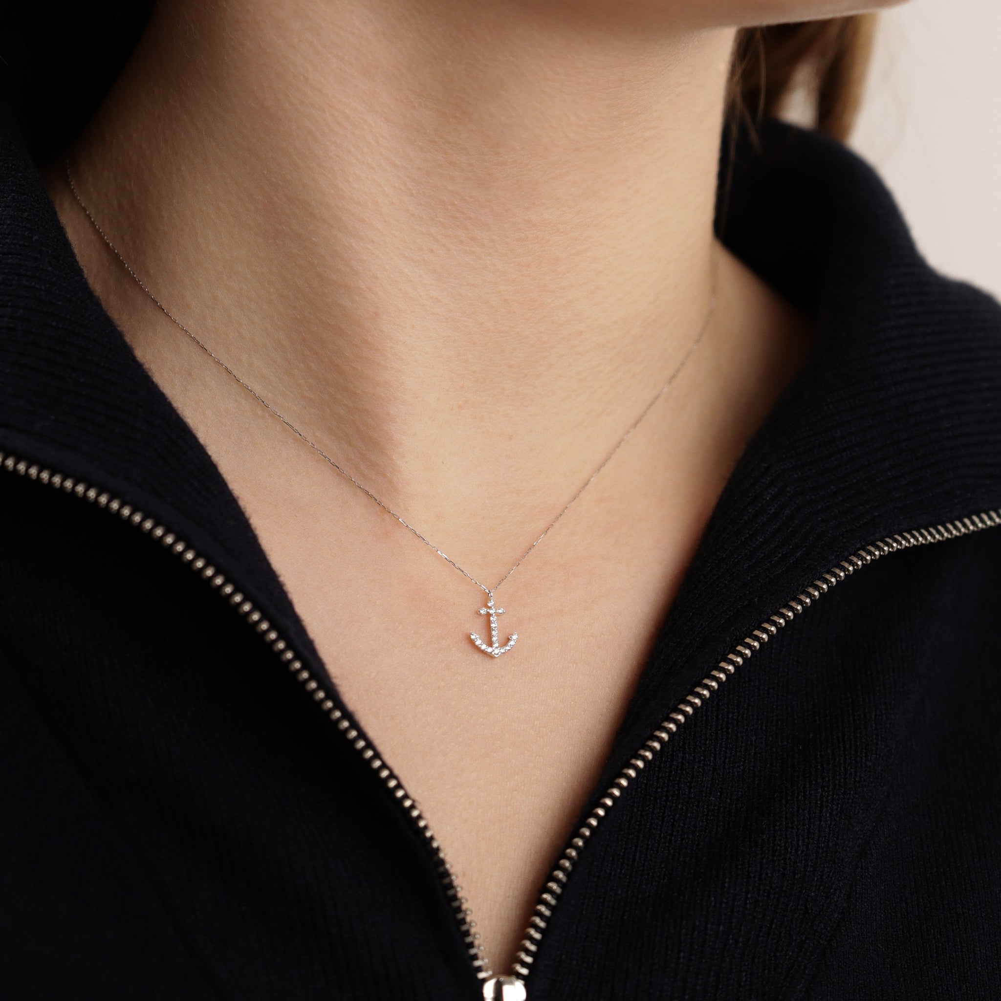 Damenhalskette aus 18k Weißgold mit diamantbesetztem Anker-Anhänger, getragen am Hals - eleganter maritimer Schmuck.