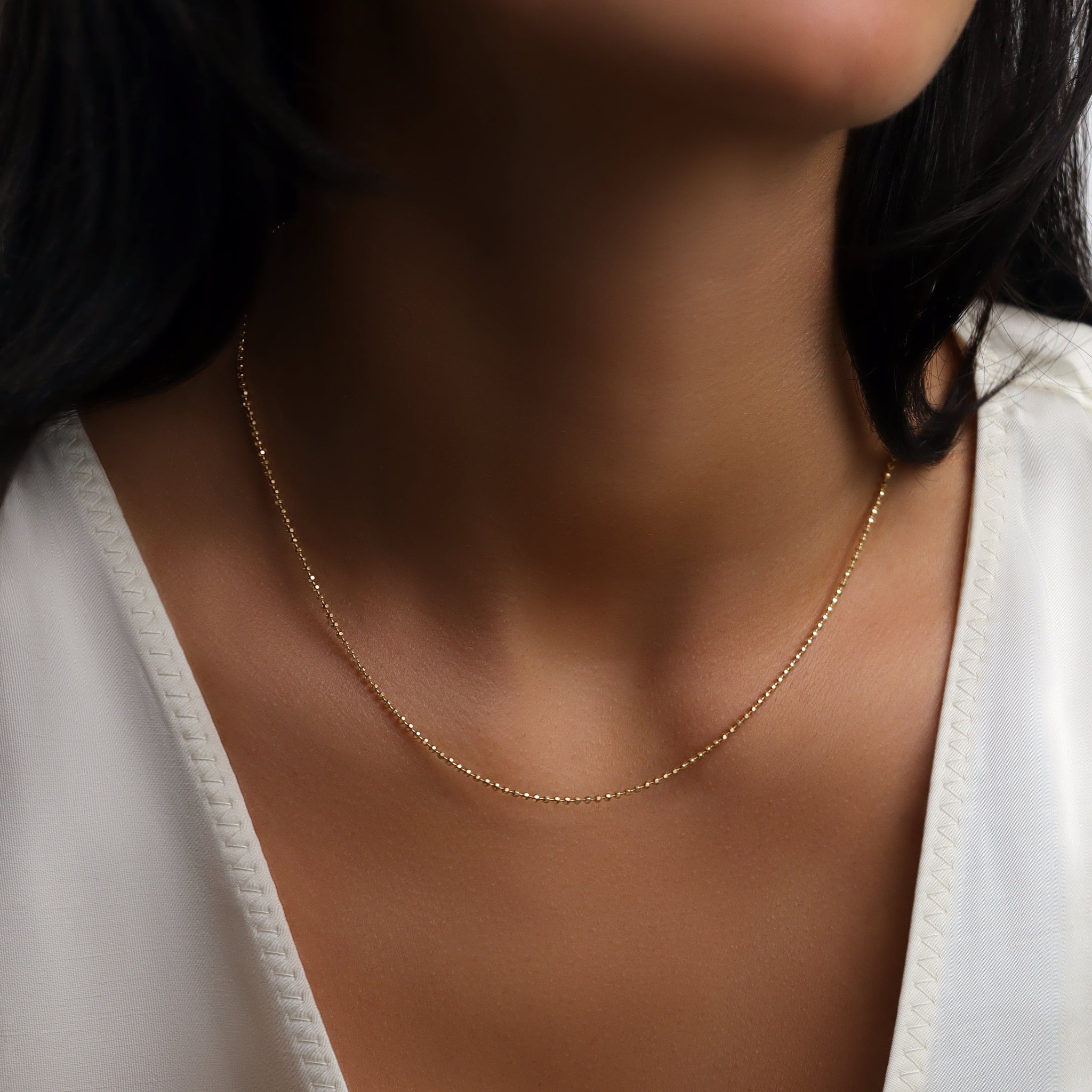 Alba Halskette aus 18K Gold - feine minimalistische Goldkette, getragen am Hals.